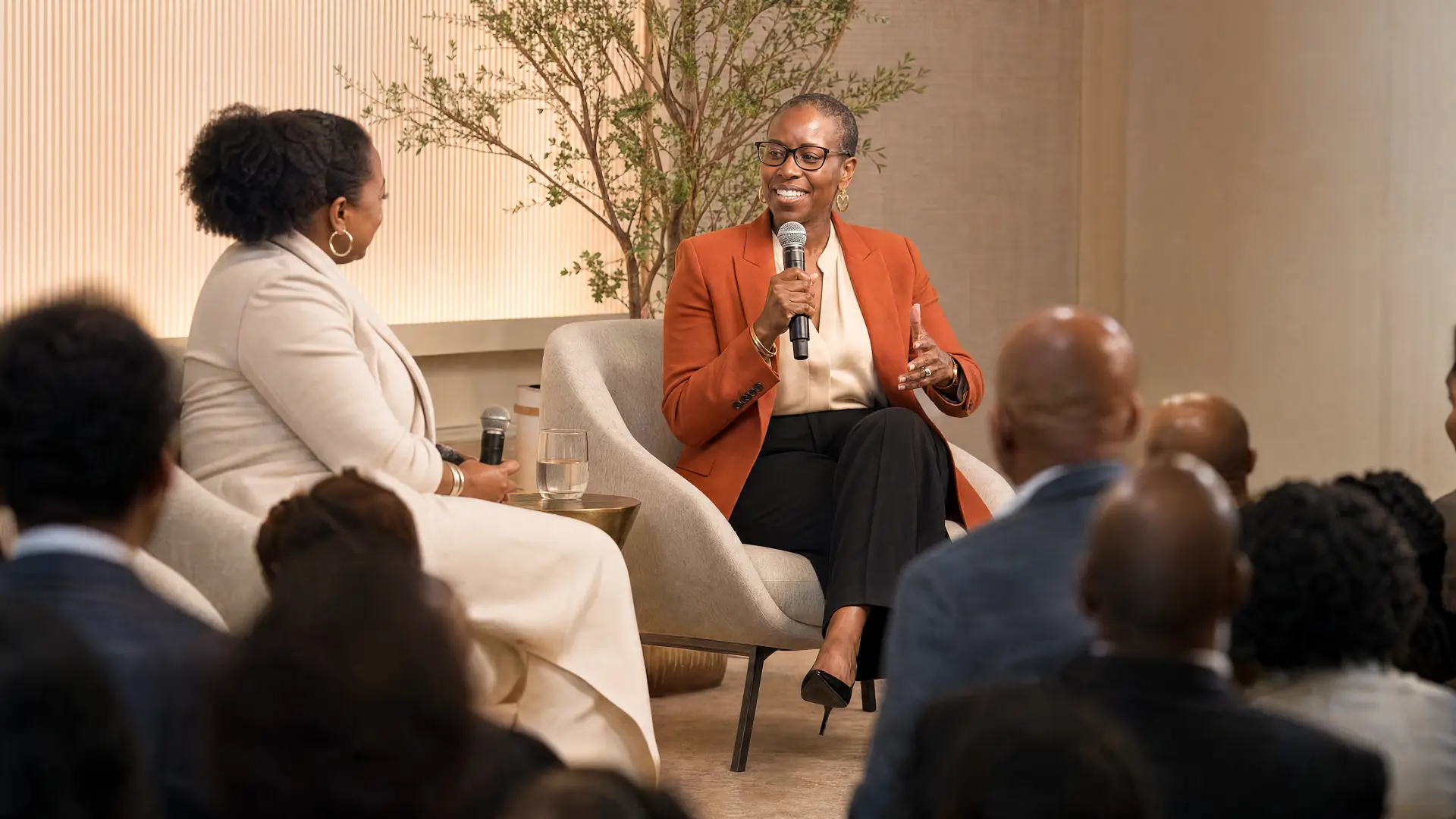 Nyia Harris moderating a panel discussion, listening to a panelist