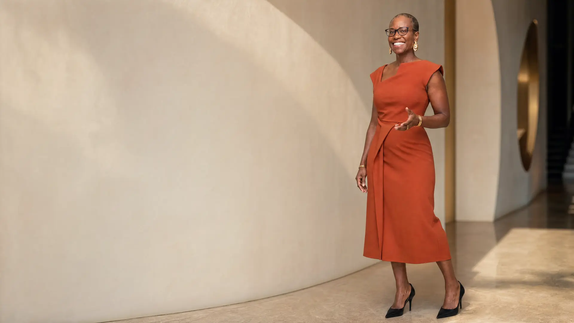 Nyia Harris standing confidently in a warm modern corridor